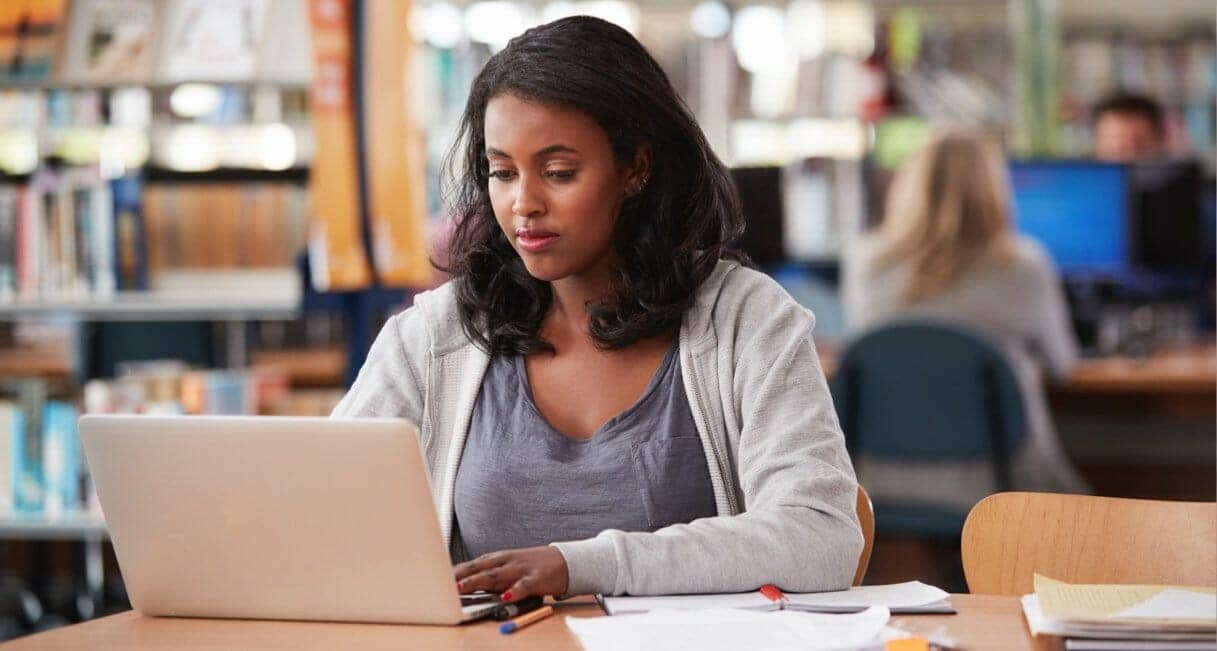 Student studying on laptop in the library